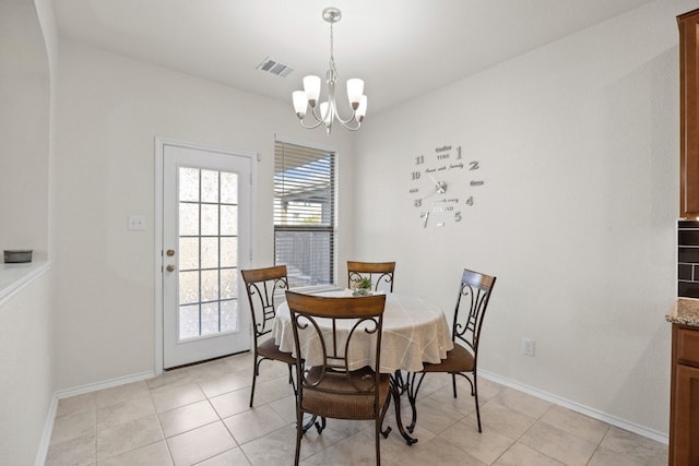 dining area with a chandelier and light tile patterned floors