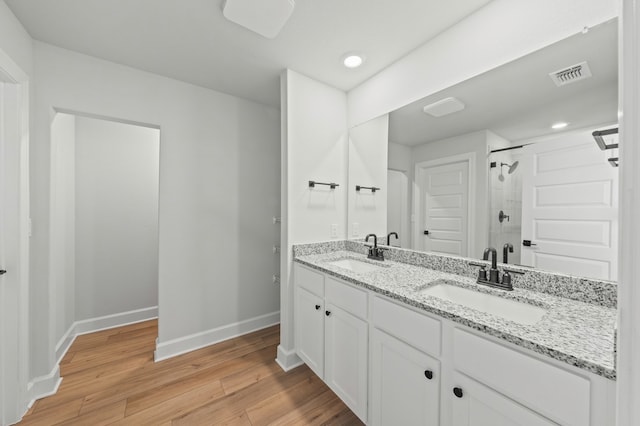 bathroom with vanity, hardwood / wood-style flooring, and a shower with door