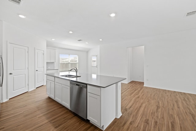 kitchen with sink, stainless steel dishwasher, white cabinets, and an island with sink