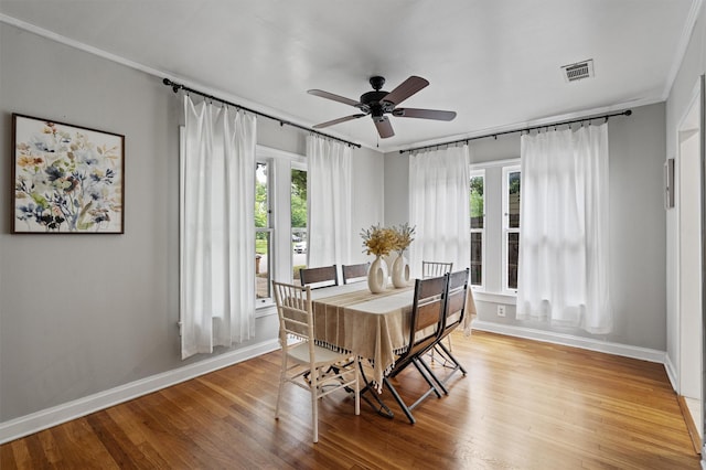 dining area featuring crown molding, a healthy amount of sunlight, light hardwood / wood-style flooring, and ceiling fan