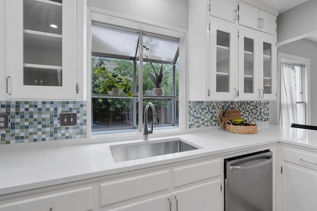 kitchen with sink, backsplash, white cabinets, and dishwasher