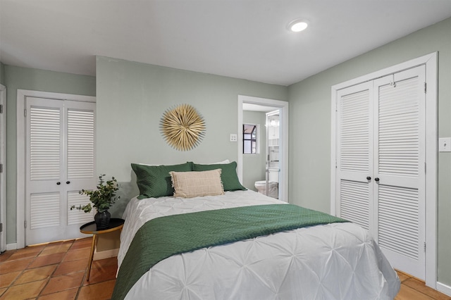 bedroom featuring tile patterned floors, ensuite bath, and multiple closets