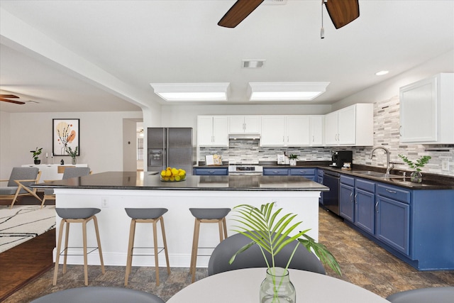 kitchen featuring white cabinets, blue cabinetry, appliances with stainless steel finishes, and sink