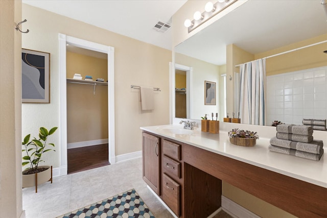 bathroom featuring walk in shower, tile patterned floors, and vanity