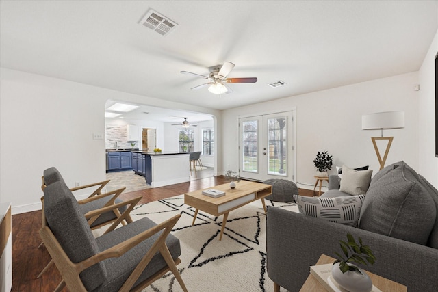 living room with hardwood / wood-style flooring, ceiling fan, and french doors