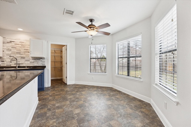 kitchen with sink, white cabinetry, ceiling fan, and tasteful backsplash