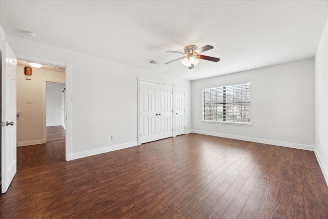 unfurnished bedroom with ceiling fan and dark wood-type flooring