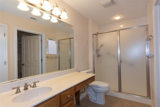 bathroom featuring tile patterned flooring, vanity, toilet, and a shower with shower door