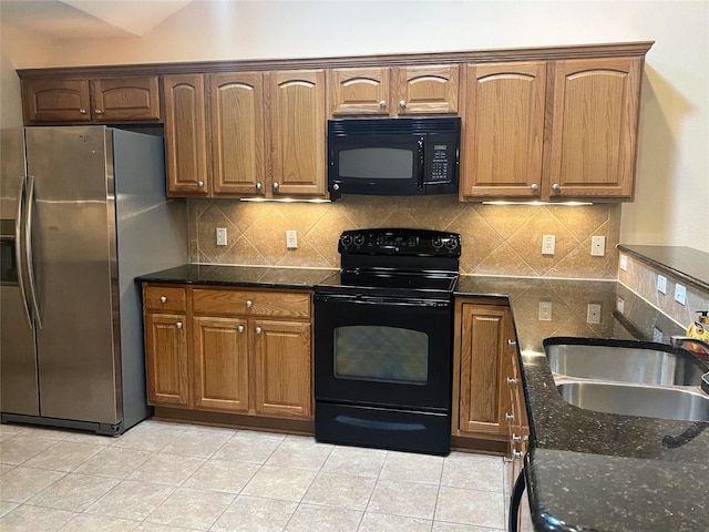 kitchen featuring light tile patterned floors, dark stone countertops, sink, and black appliances