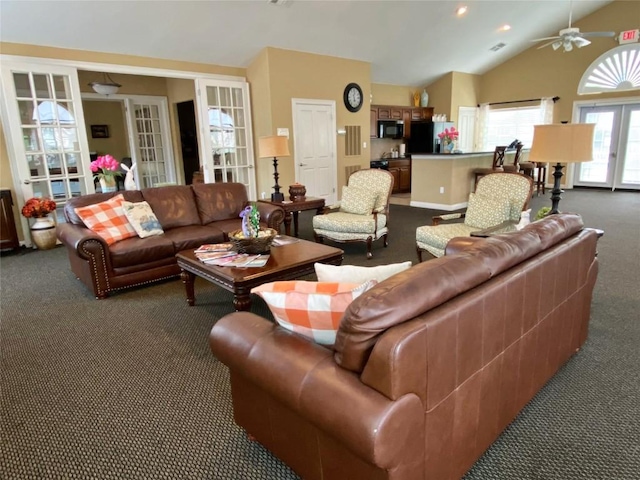 living room with lofted ceiling, french doors, ceiling fan, and dark colored carpet