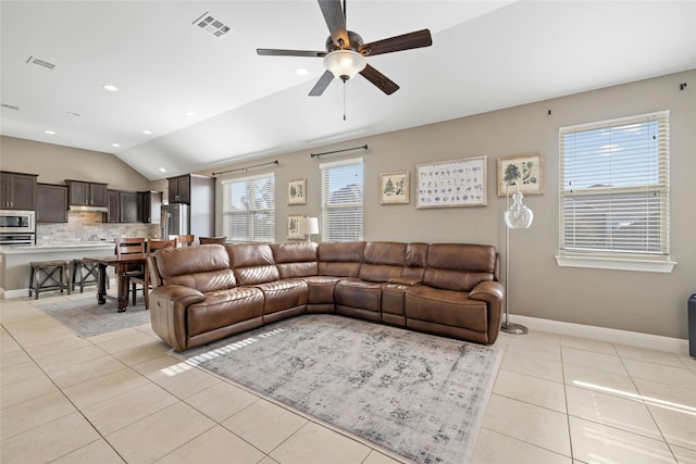 living room featuring vaulted ceiling, a wealth of natural light, ceiling fan, and light tile patterned floors