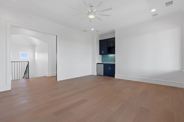 spare room with ceiling fan, crown molding, and wood-type flooring