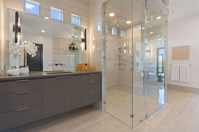 bathroom featuring a shower with door, a chandelier, and vanity