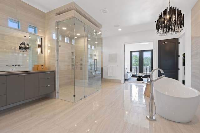 bathroom with vanity, shower with separate bathtub, a notable chandelier, and french doors