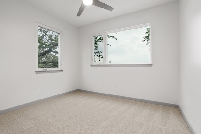 spare room with ceiling fan, a wealth of natural light, and carpet flooring