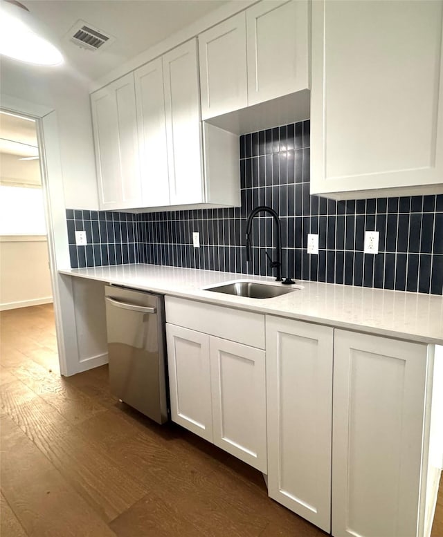 kitchen featuring sink, backsplash, stainless steel dishwasher, and white cabinetry