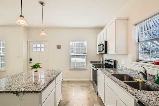 kitchen featuring sink, white cabinetry, a center island, stone counters, and stainless steel appliances