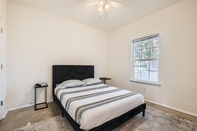 bedroom with ceiling fan and concrete flooring