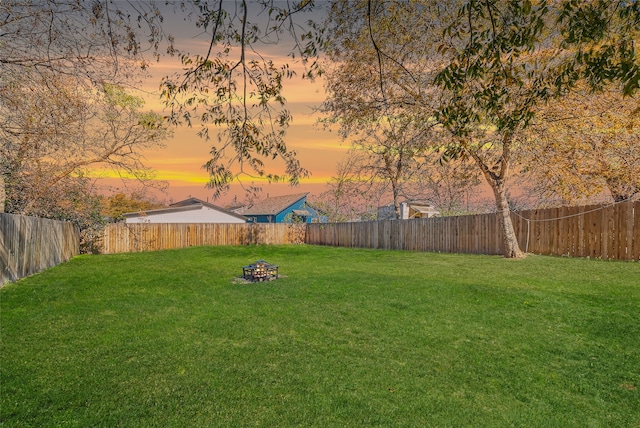 yard at dusk featuring a fire pit