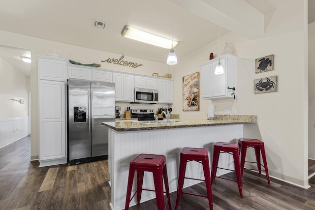 kitchen with white cabinets, sink, kitchen peninsula, pendant lighting, and stainless steel appliances