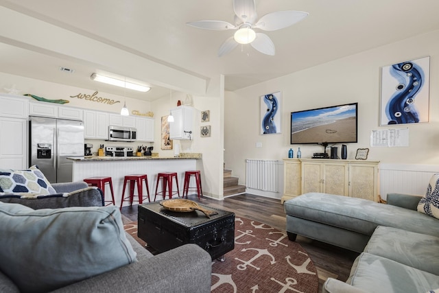 living room with ceiling fan and dark hardwood / wood-style flooring