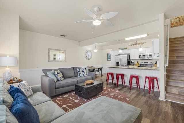 living room featuring ceiling fan and dark hardwood / wood-style flooring