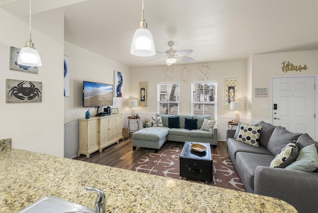 living room featuring ceiling fan and dark wood-type flooring