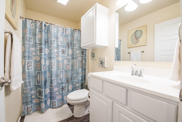 bathroom with vanity, toilet, and hardwood / wood-style floors