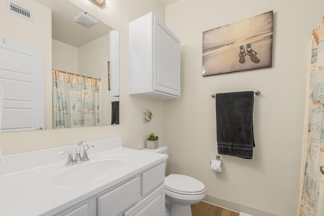 bathroom with vanity, toilet, and hardwood / wood-style flooring