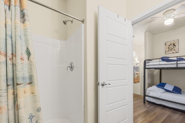 bathroom featuring walk in shower, ceiling fan, and hardwood / wood-style floors