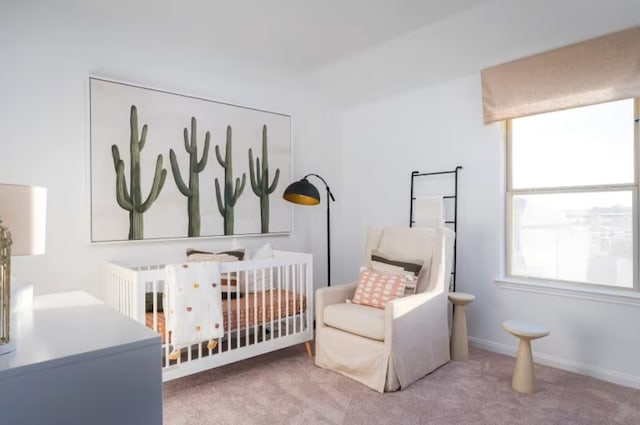 bedroom featuring a nursery area, carpet flooring, and multiple windows