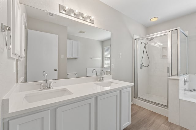 full bathroom featuring vanity, wood-type flooring, independent shower and bath, and toilet