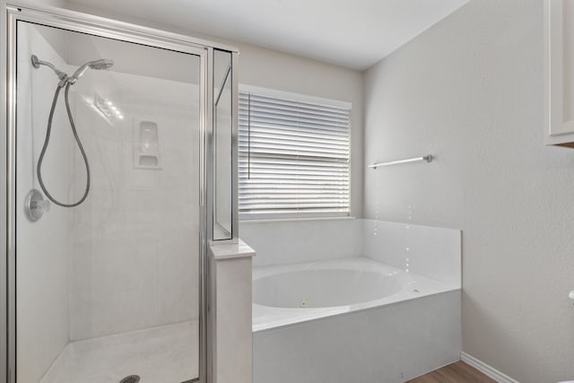 bathroom with plus walk in shower and hardwood / wood-style floors