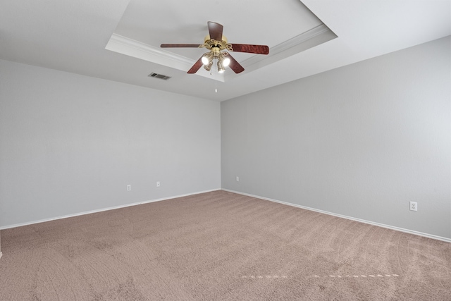 carpeted empty room with crown molding, a tray ceiling, and ceiling fan