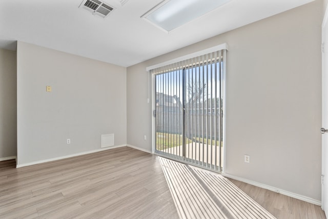 spare room featuring plenty of natural light and light hardwood / wood-style floors