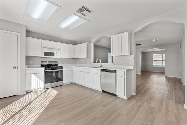 kitchen featuring white cabinetry, appliances with stainless steel finishes, sink, and light hardwood / wood-style floors