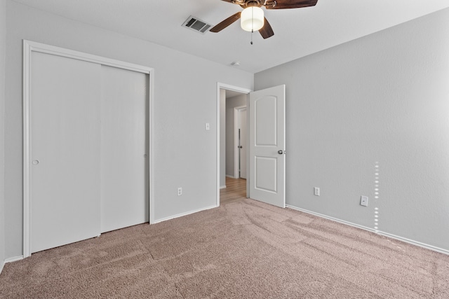 unfurnished bedroom with ceiling fan, carpet flooring, and a closet