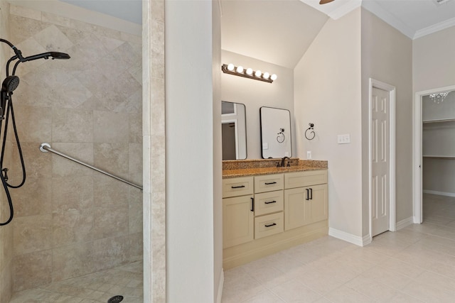 bathroom featuring tile patterned floors, vanity, ornamental molding, vaulted ceiling, and tiled shower