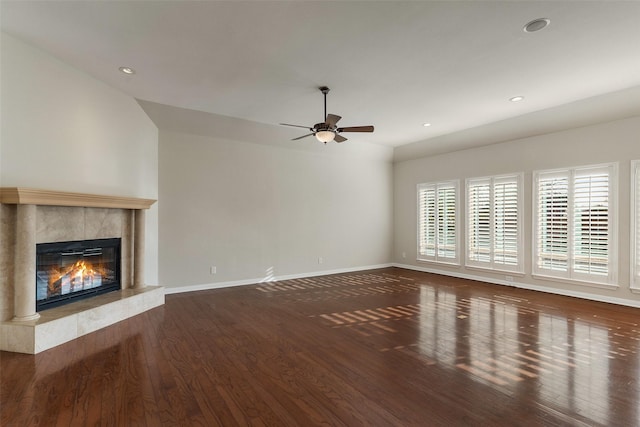 unfurnished living room with ceiling fan, a high end fireplace, and dark hardwood / wood-style flooring