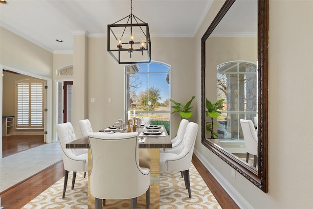 dining space with ornamental molding, a chandelier, and hardwood / wood-style floors