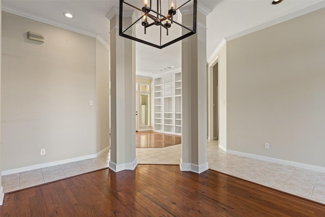 interior space with wood-type flooring, built in features, ornamental molding, and an inviting chandelier