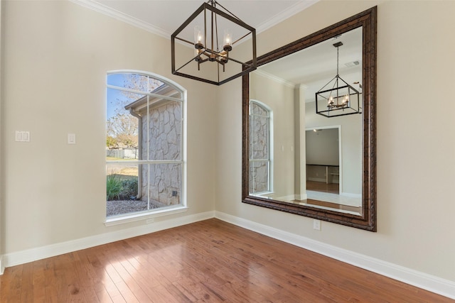 unfurnished dining area featuring plenty of natural light, ornamental molding, and a notable chandelier