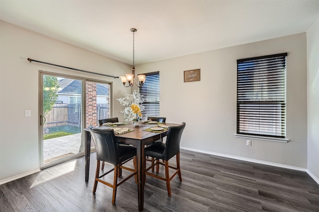 dining space with dark hardwood / wood-style flooring and a notable chandelier