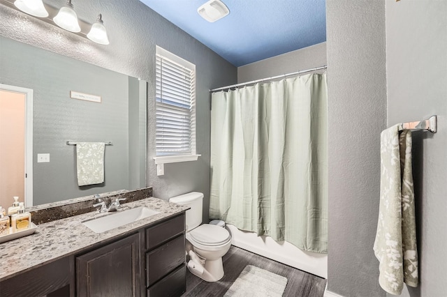 full bathroom featuring shower / bath combo with shower curtain, hardwood / wood-style floors, toilet, and vanity