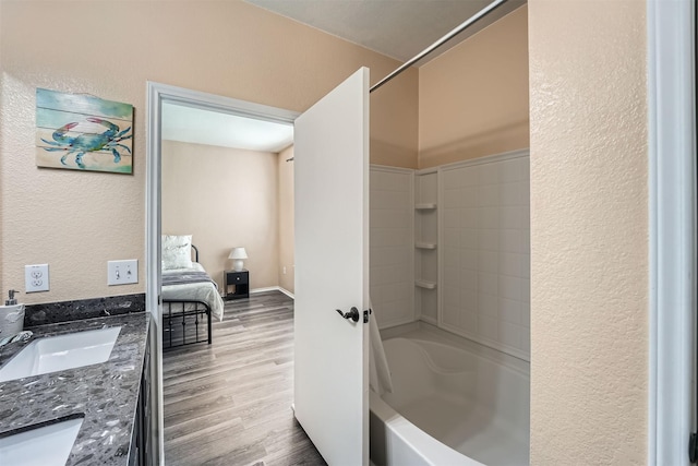 bathroom with hardwood / wood-style floors, bathtub / shower combination, and vanity