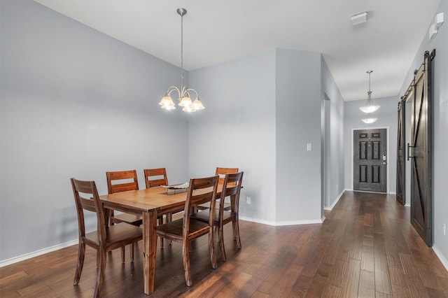 dining area with dark hardwood / wood-style flooring, a barn door, and a notable chandelier