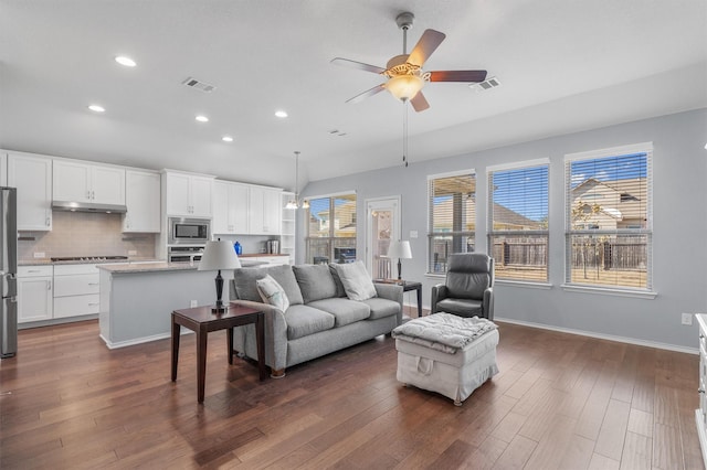 living room featuring ceiling fan and dark hardwood / wood-style flooring