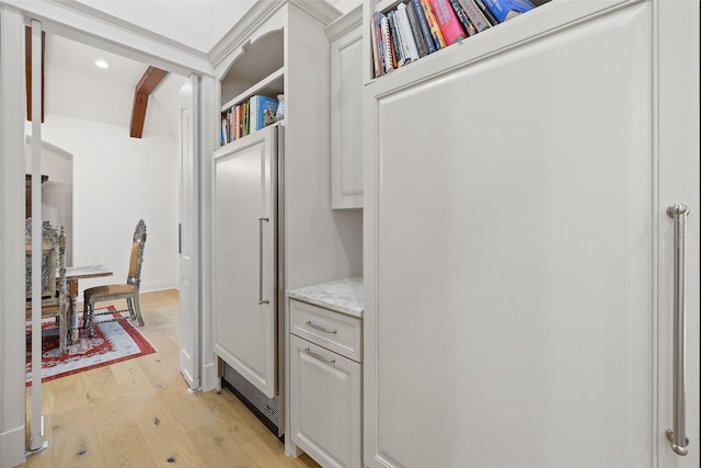 hallway with light wood-type flooring and beamed ceiling