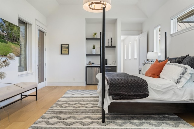 bedroom with vaulted ceiling and light hardwood / wood-style floors