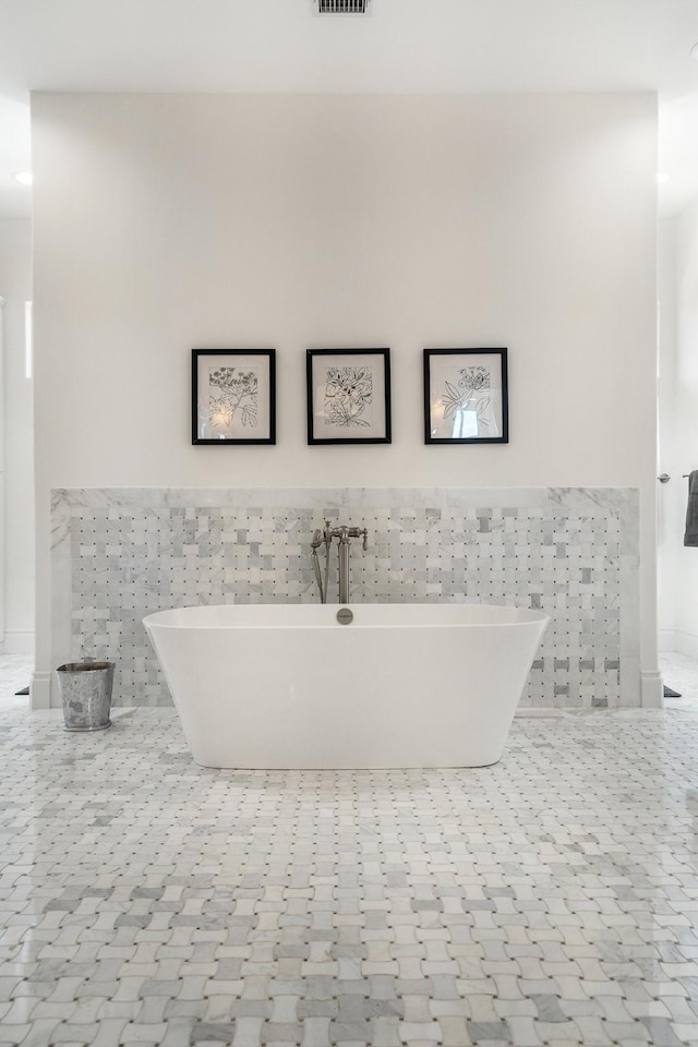 bathroom featuring a tub, tile walls, and tile patterned flooring